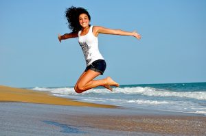 Image of In-Good-Place-Grants-Open Happy jumping woman on beach